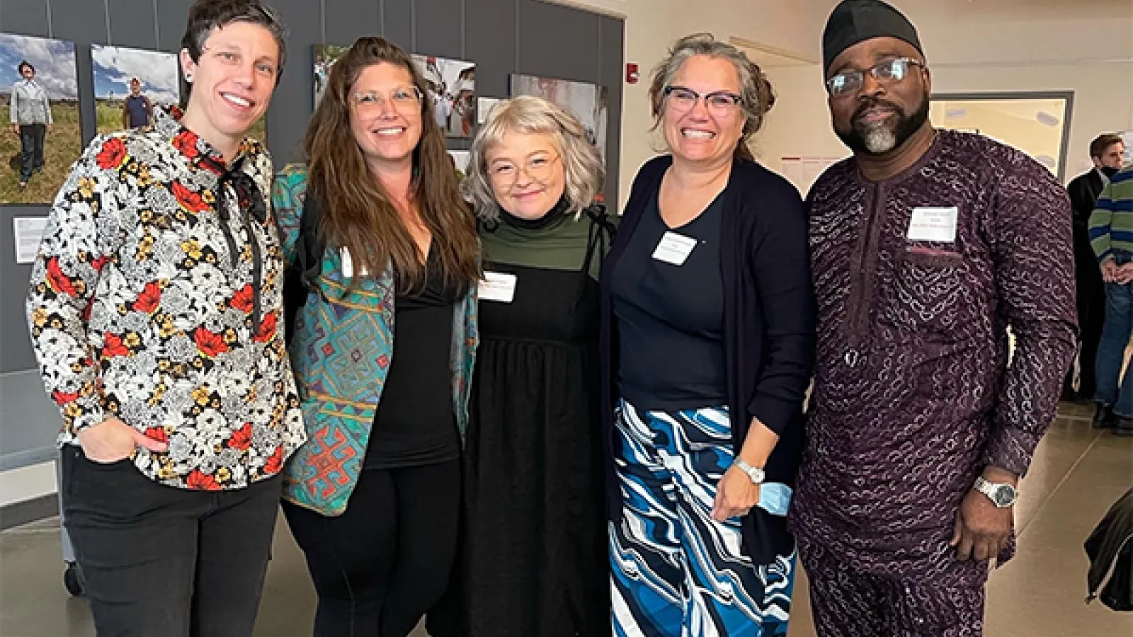 Five GRAE participants standing in a room smile at camera