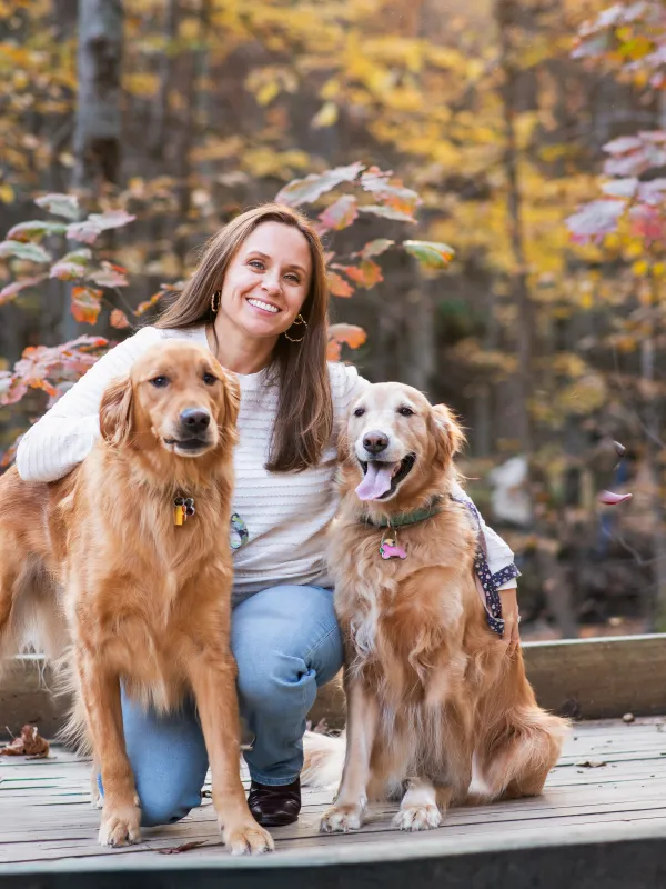 A woman with two golden retrievers